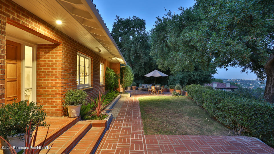 1336 Inverness Drive Pasadena, CA 91103 - Photo 37 of 42 a view of a patio with table and chairs under an umbrella with wooden fence