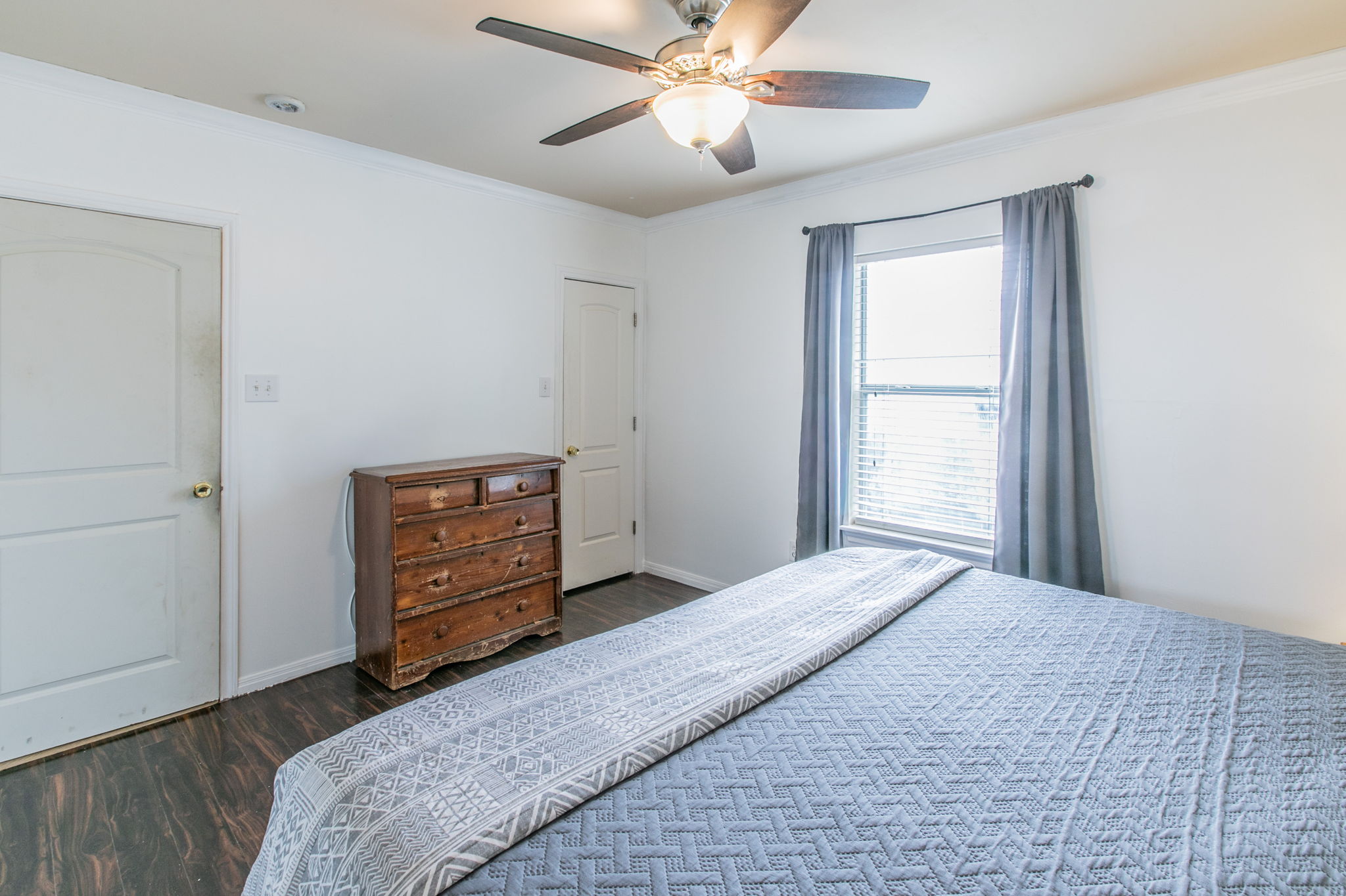 1107 Vargas Road Austin, TX 78741 - Photo 9 of 17 A comforting bedroom features rich wood flooring, crown molding, and a well-lit window.