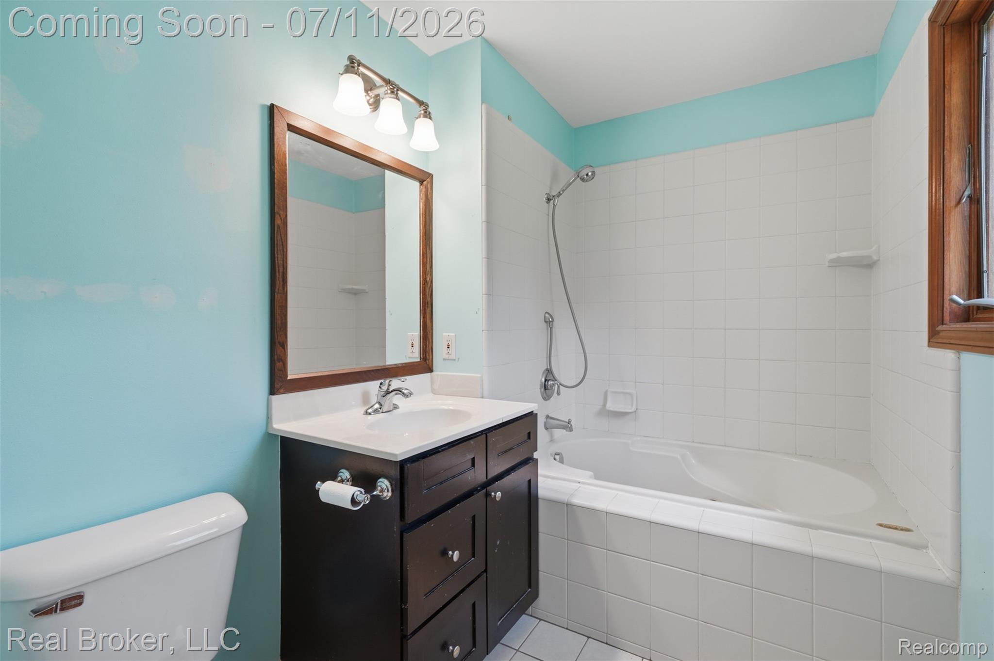 1050 West Brocker Road Metamora, MI 48455 - Photo 21 of 55 Bathroom featuring a dark wood-finish vanity with a white integrated sink, a matching framed mirror, and a three-light fixture