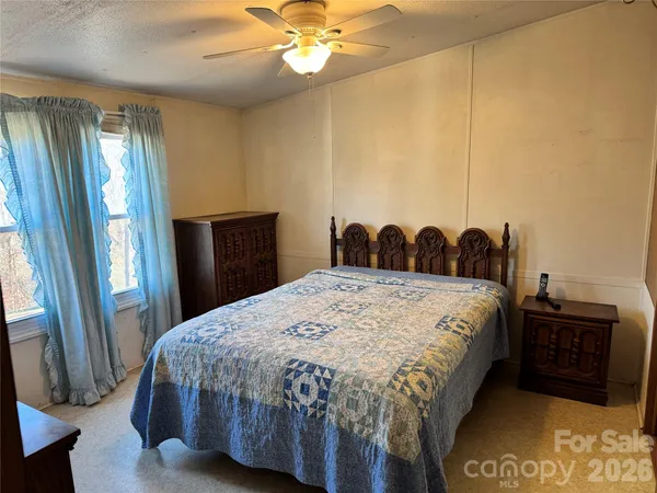 a bedroom with a bed and a large mirror