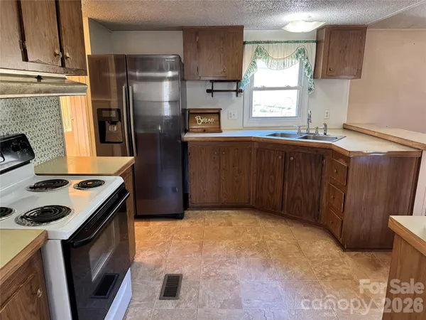 a kitchen with stainless steel appliances granite countertop a refrigerator a stove a sink and a microwave