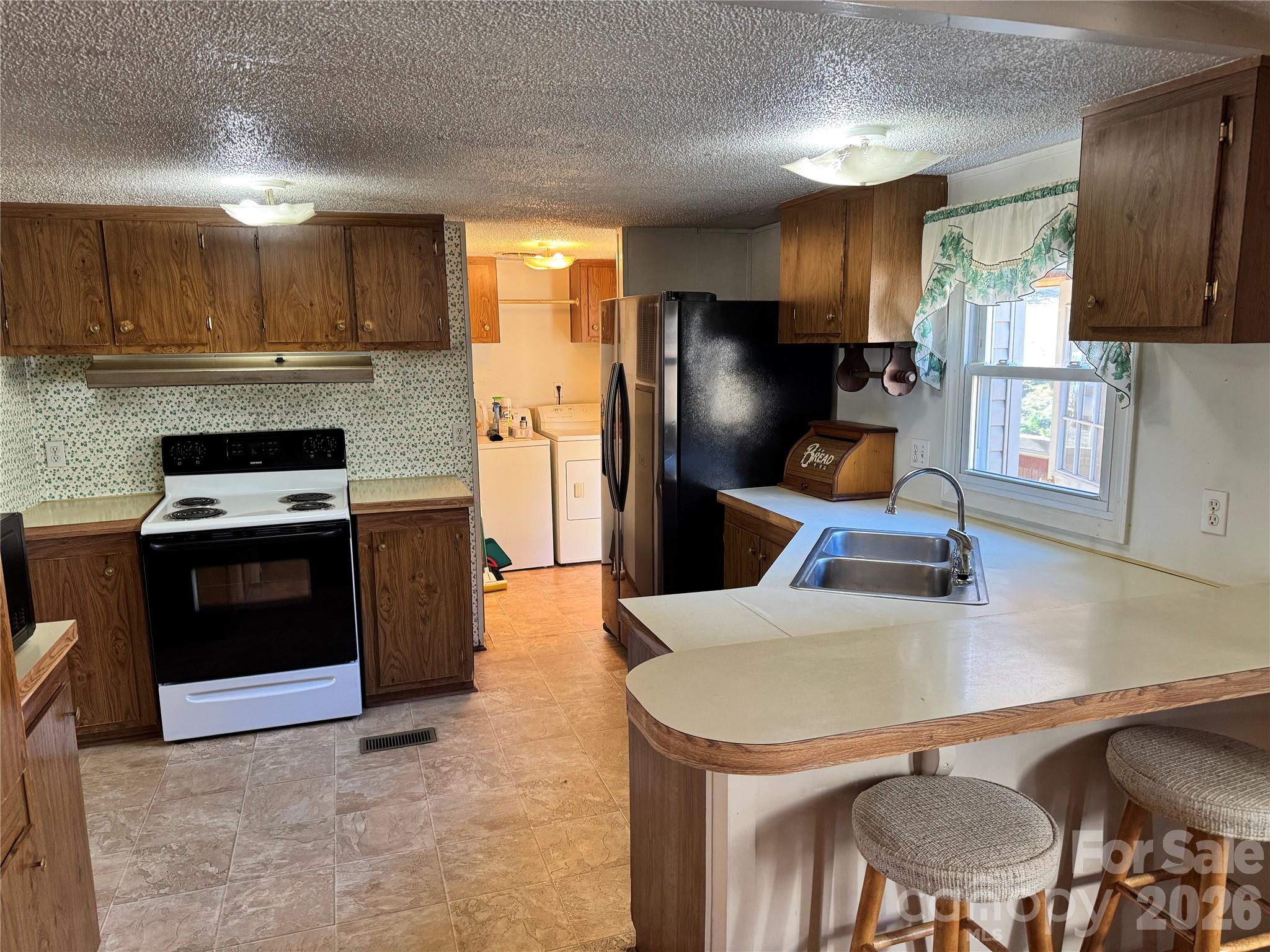 2448 Christopher Road Morganton, NC 28655 - Photo 8 of 32 a kitchen with stainless steel appliances a stove a refrigerator a sink a dining table and chairs