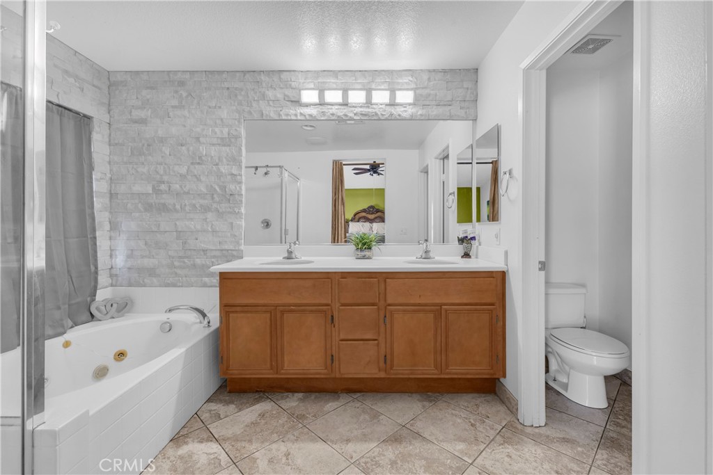 48734 Chichen Itza Road Coachella, CA 92236 - Photo 9 of 18 a spacious bathroom with a granite countertop sink a mirror a bathtub and a shower