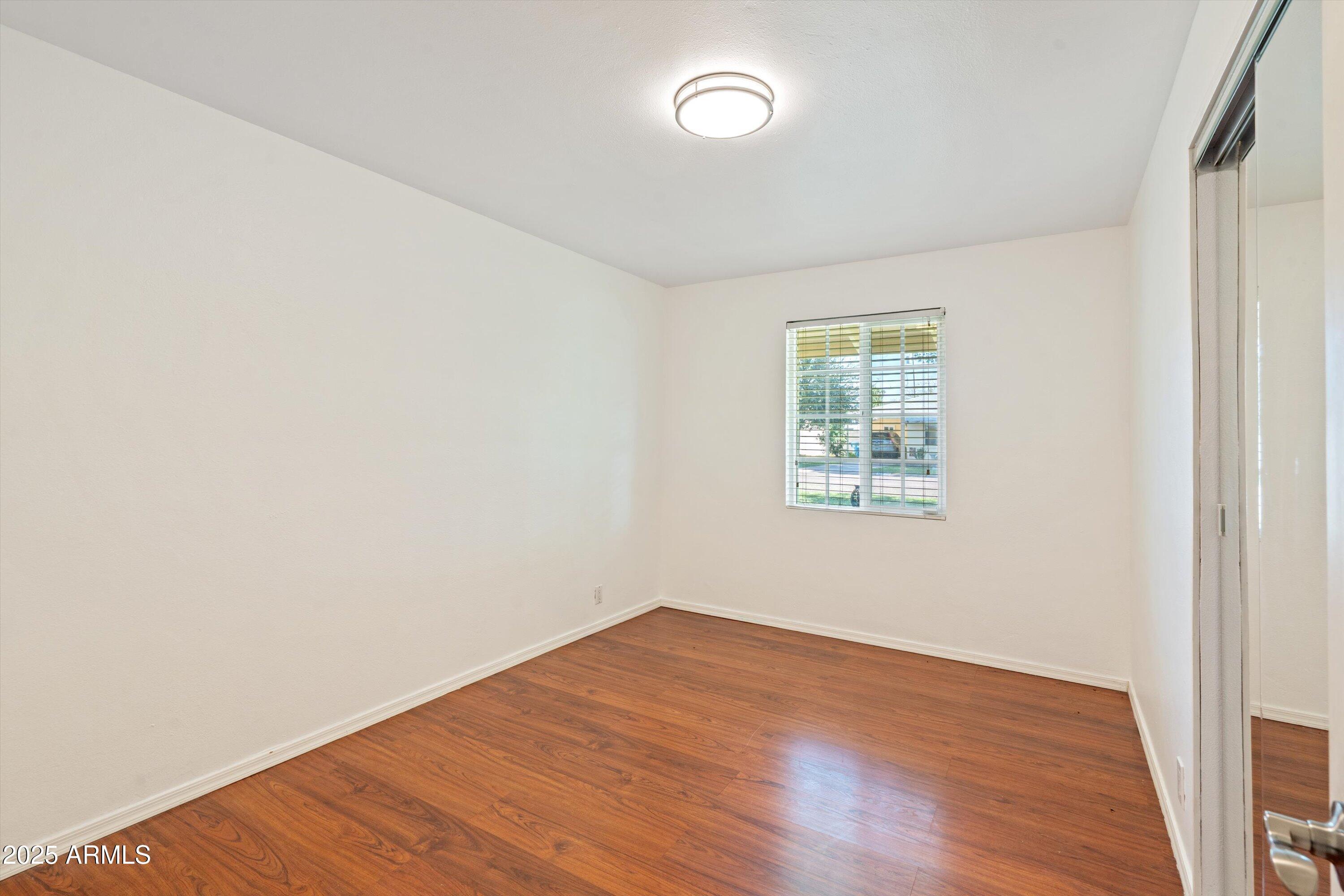 8216 North 9th Street Phoenix, AZ 85020 - Photo 18 of 39 an empty room with wooden floor and windows