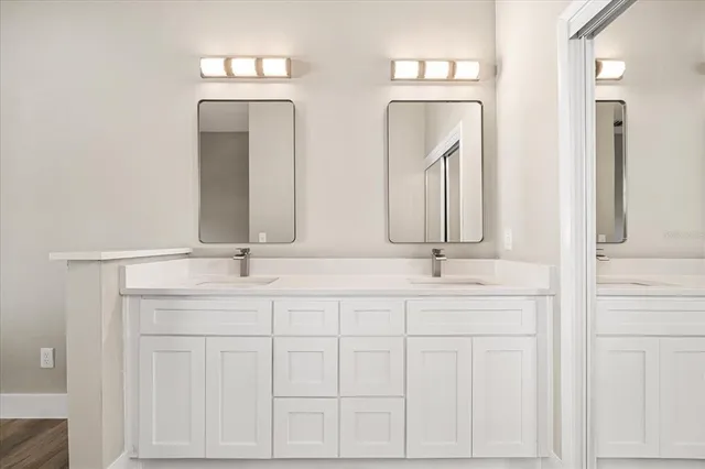 a bathroom with double vanity sinks and a mirror