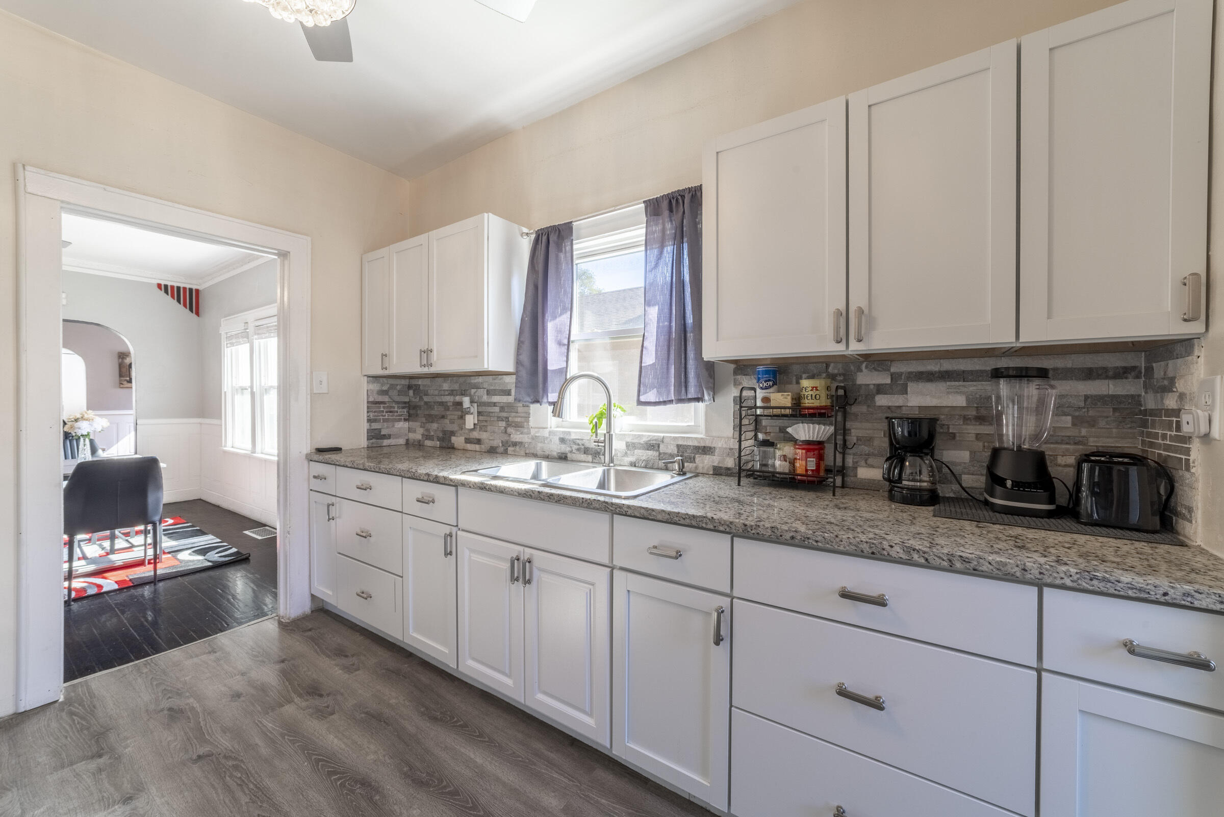 314 Cleveland Street Gary, IN 46404 - Photo 16 of 60 a kitchen with granite countertop white cabinets and white appliances