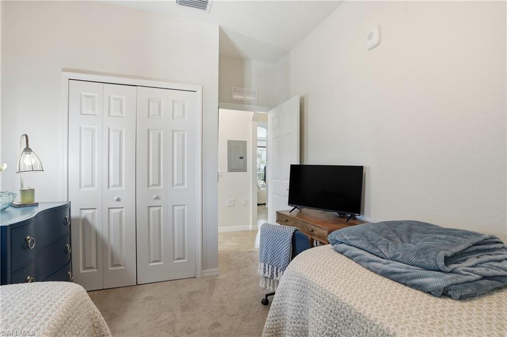 9830 Giaveno Circle, Unit 1646 Naples, FL 34113 - Photo 17 of 30 a bedroom with a bed and a flat screen tv