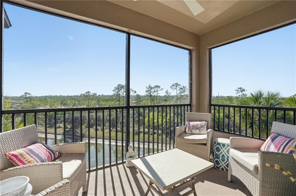 9830 Giaveno Circle, Unit 1646 Naples, FL 34113 - Photo 2 of 30 a balcony with wooden floor and outdoor seating