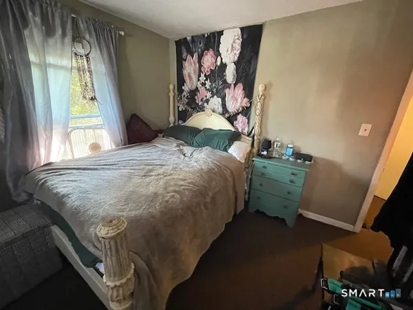 a bedroom with a bed and a painting on the wall