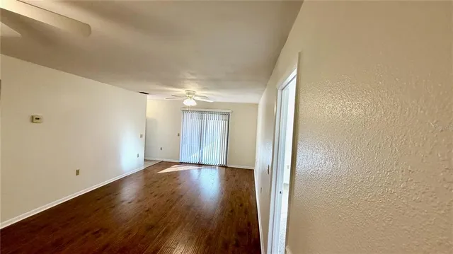 a view of a room with wooden floor and white walls