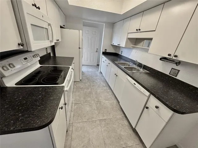 a kitchen with white cabinets and white appliances