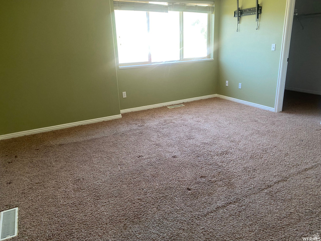 83 Canterbury Circle Logan, UT 84321 - Photo 15 of 23 Unfurnished bedroom with a walk in closet and carpet
