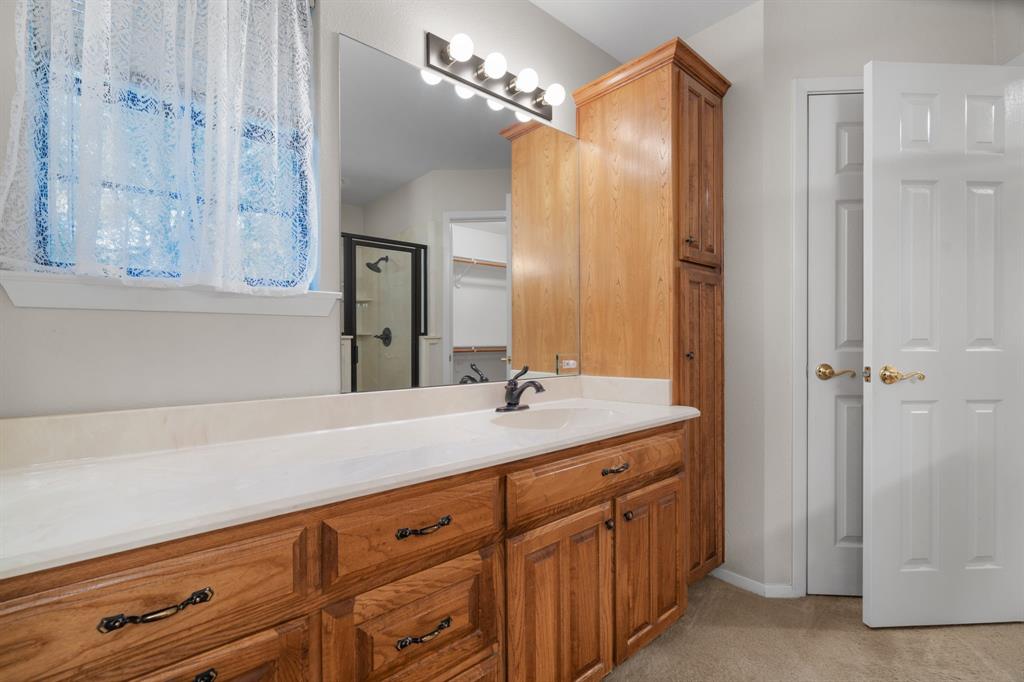 1317 Timber Ridge Road Weatherford, TX 76088 - Photo 17 of 40 a bathroom with a granite countertop sink and a mirror