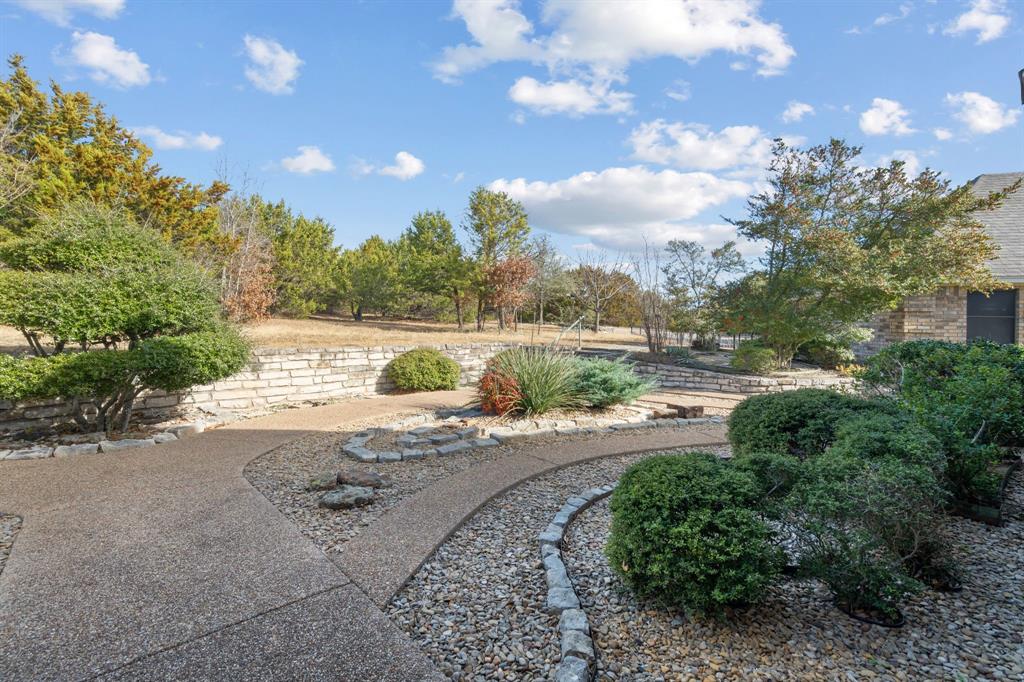 1317 Timber Ridge Road Weatherford, TX 76088 - Photo 3 of 40 a view of a yard with plants and large trees