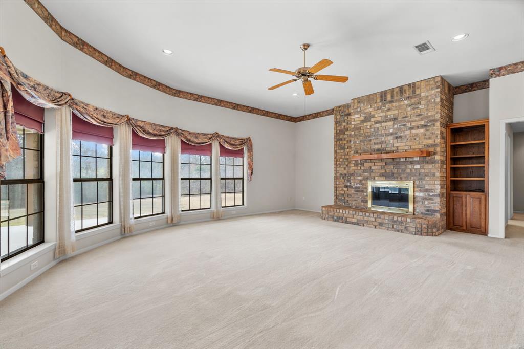 1317 Timber Ridge Road Weatherford, TX 76088 - Photo 5 of 40 a view of an empty room with a fireplace and a window