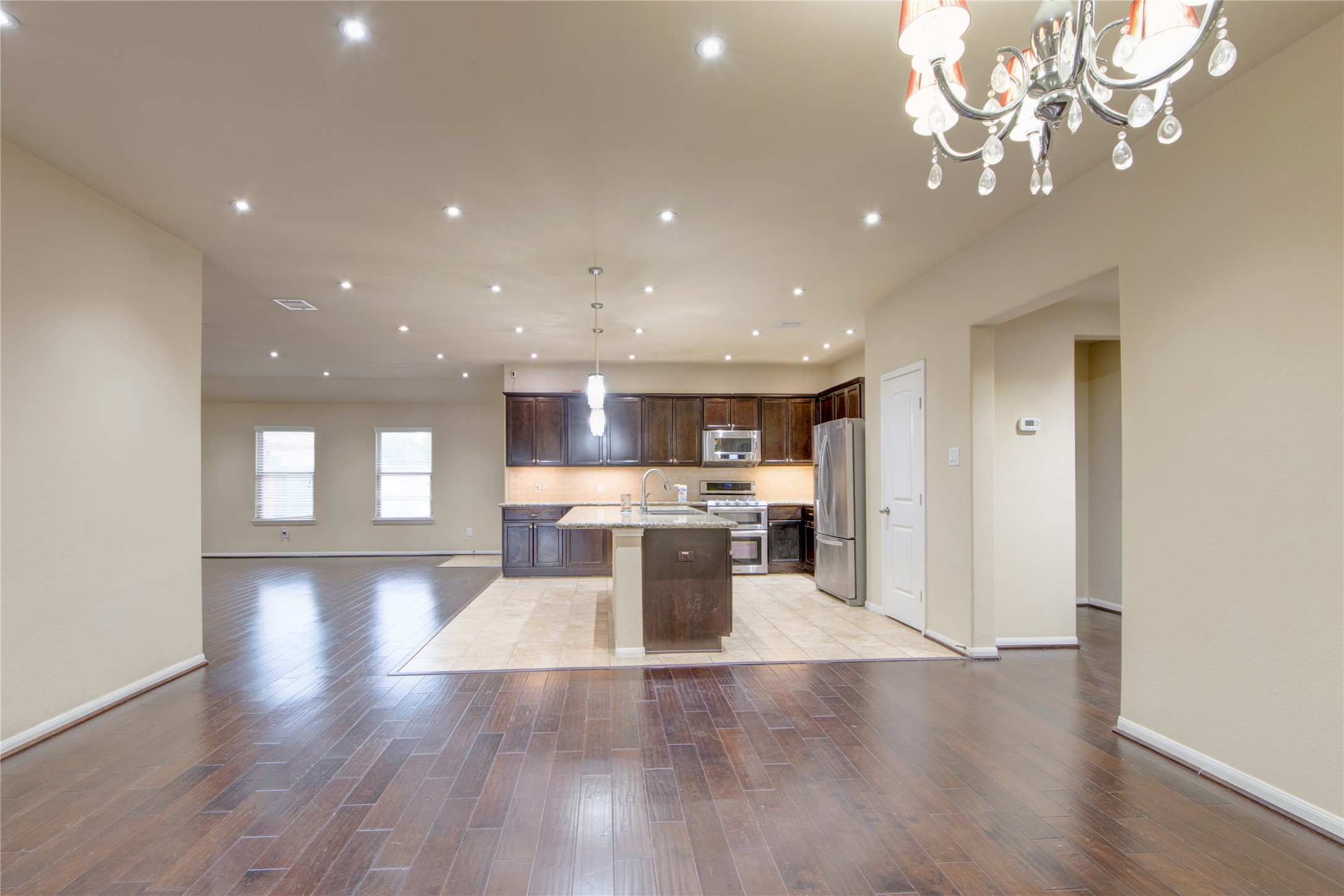 9322 Limestone Ranch Lane Richmond, TX 77407 - Photo 7 of 40 a view of a dining room with furniture a chandelier and wooden floor