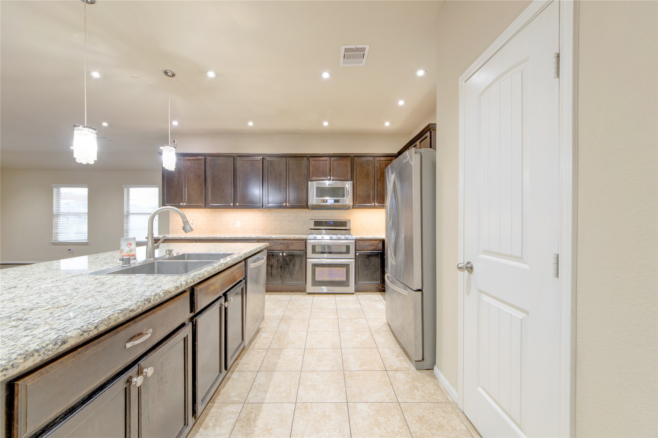 9322 Limestone Ranch Lane Richmond, TX 77407 - Photo 9 of 40 a kitchen with stainless steel appliances granite countertop a refrigerator and a sink