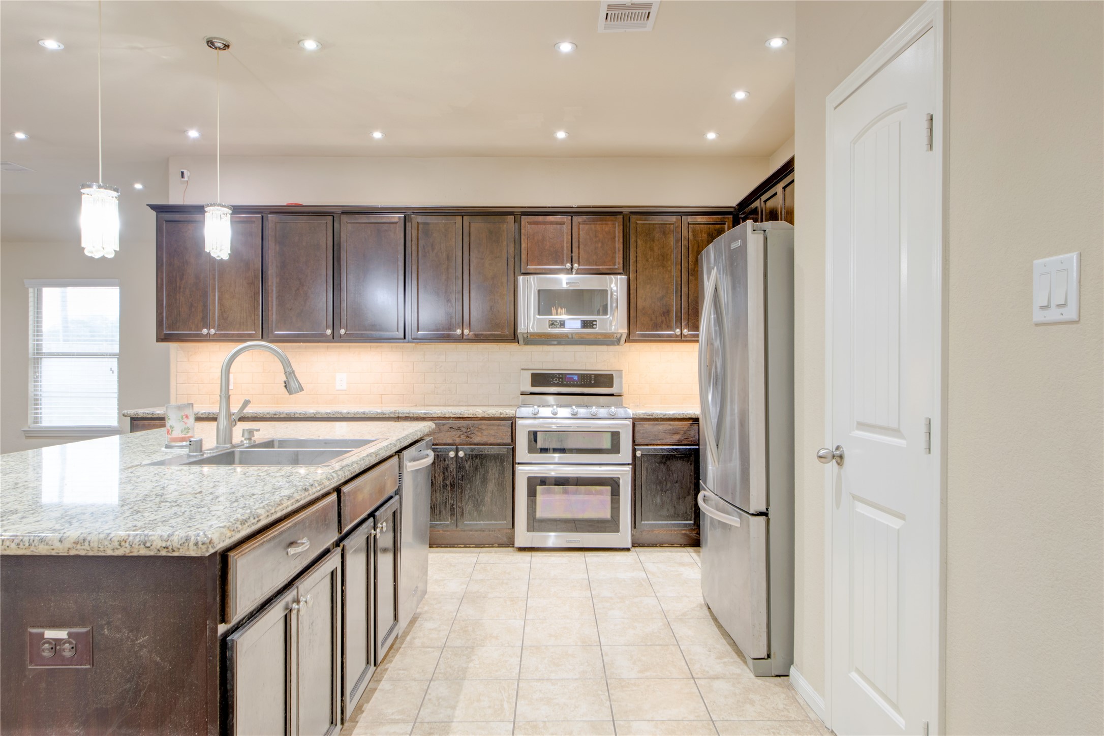 9322 Limestone Ranch Lane Richmond, TX 77407 - Photo 10 of 40 a kitchen with stainless steel appliances granite countertop a refrigerator and a sink