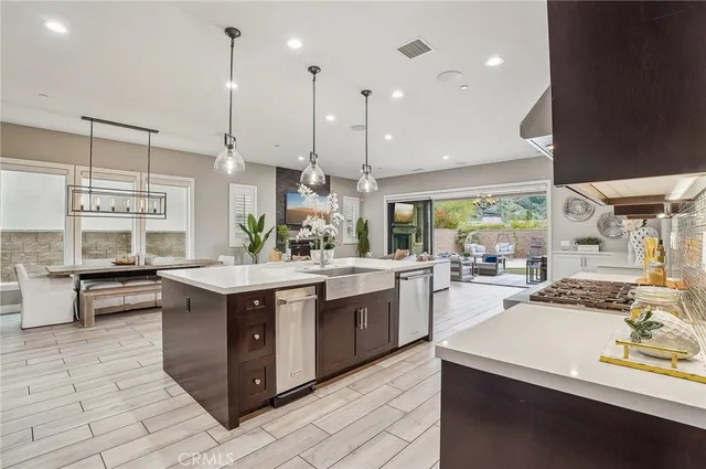 a large kitchen with kitchen island a large counter space appliances and a view of living room