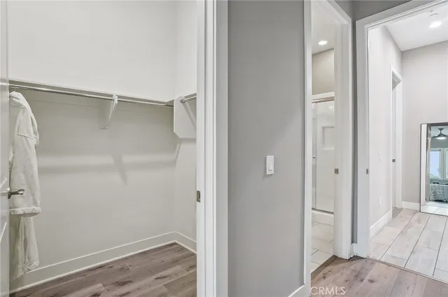 a bedroom with a bed a window and potted plant on the dresser