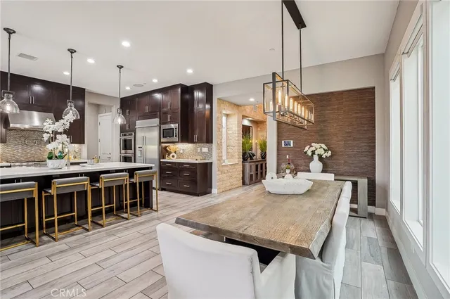 a kitchen with stainless steel appliances granite countertop a kitchen island a stove a table and chairs