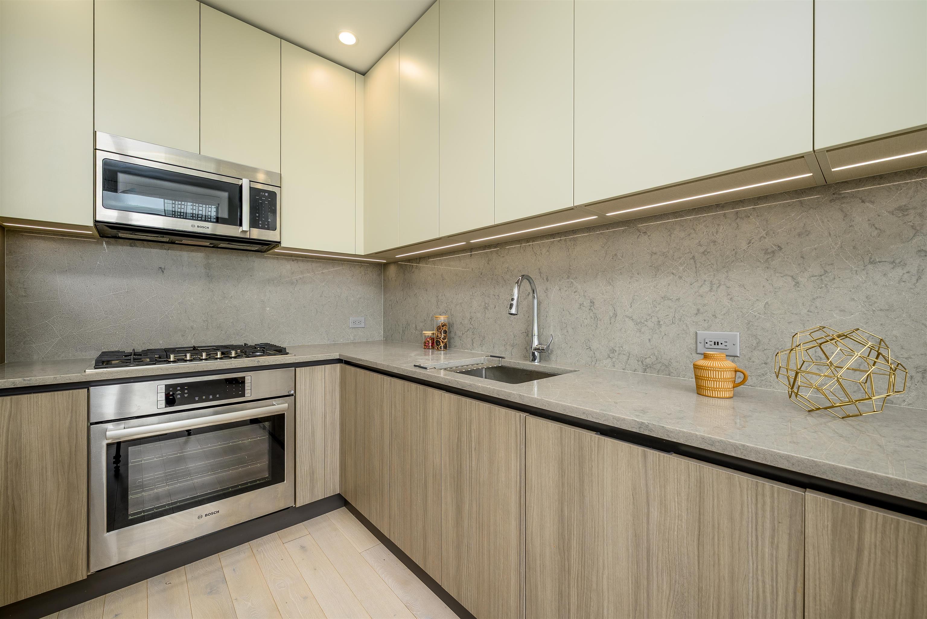 155 Bay Street, Unit R3102 Jersey City, NJ 07302 - Photo 2 of 21 a kitchen with stainless steel appliances granite countertop a sink and a stove
