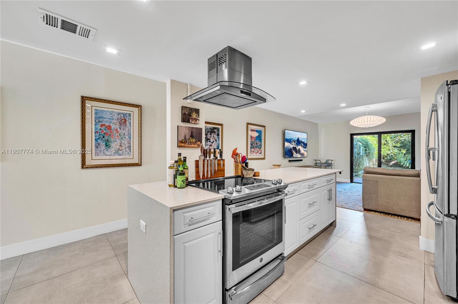 2965 Southwest 25th Terrace, Unit 2965 Miami, FL 33133 - Photo 12 of 40 a kitchen with stainless steel appliances granite countertop a stove and a sink
