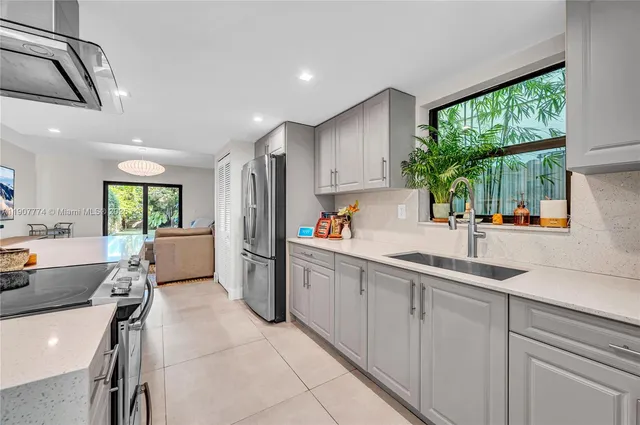 a kitchen with a sink appliances and windows