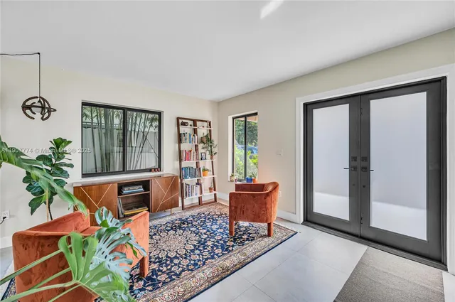 a living room with patio furniture and a potted plant