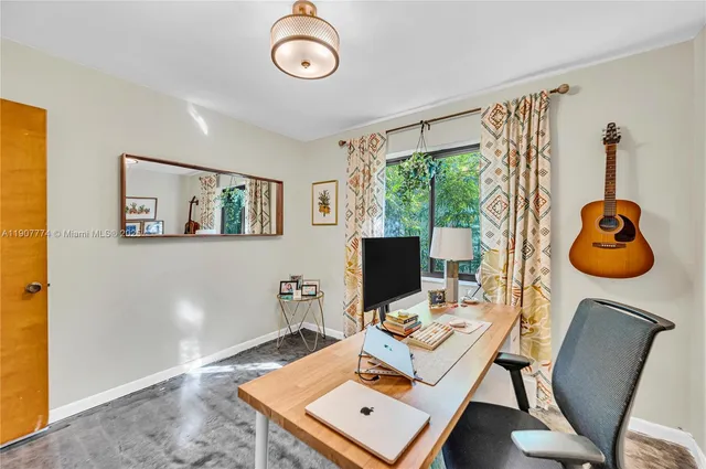 a view of a workspace with furniture and a window