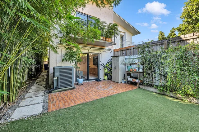a view of a chair and table in backyard of the house