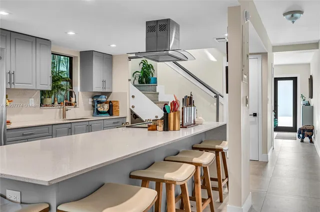 a kitchen with stainless steel appliances a table and chairs in it