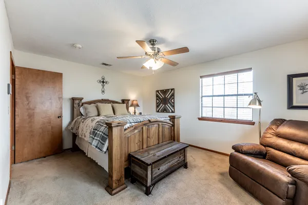 a spacious bedroom with a bed and a couch