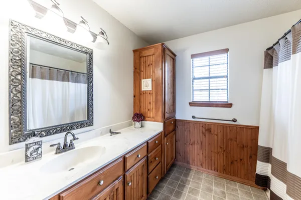 a spacious bathroom with double vanity and a mirror