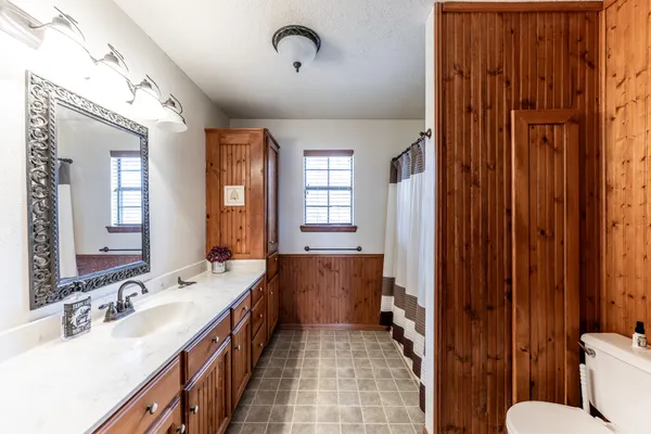 a spacious bathroom with a double vanity sink a mirror and a bathtub