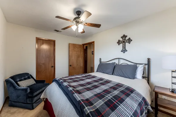 a bedroom with a large bed and a chandelier