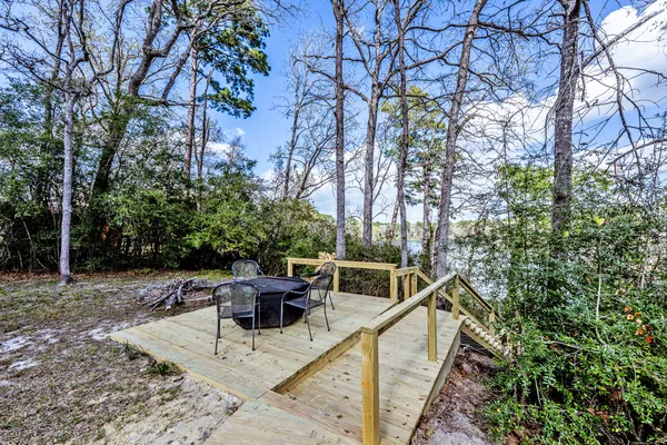 a view of house with outdoor seating and trees