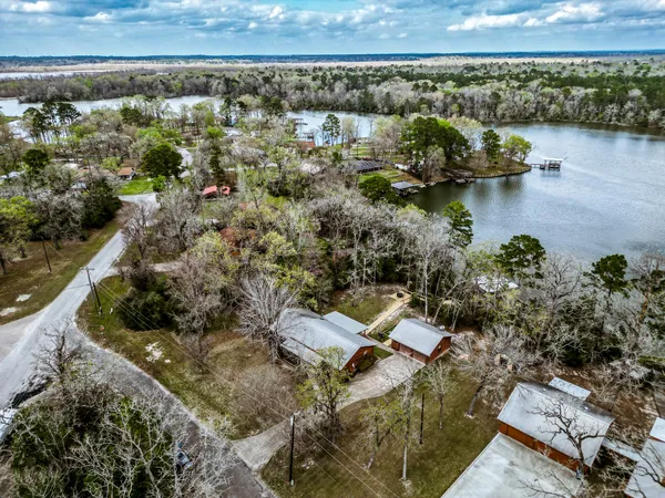 an aerial view of a house with a garden and lake view