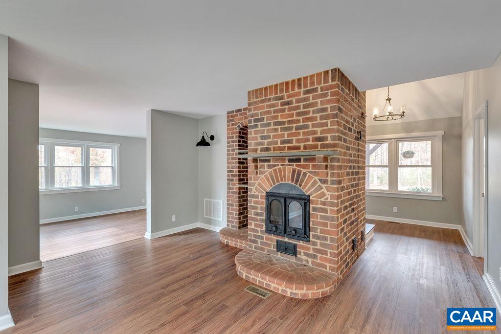 1900 Thunder Ridge Road Afton, VA 22920 - Photo 5 of 49 an empty room with wooden floor fireplace and windows