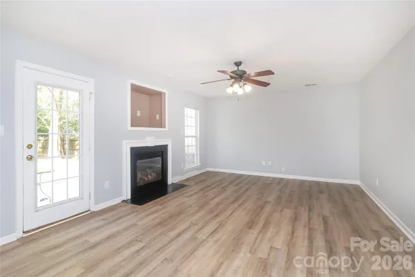 a view of an empty room with a fireplace and a window
