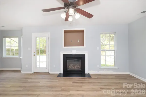 a living room with a fireplace and wooden floor
