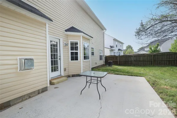 a view of a chair and table in backyard of the house