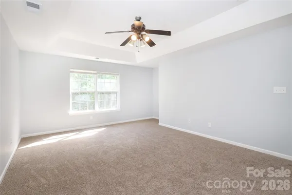 an empty room with a ceiling fan and window