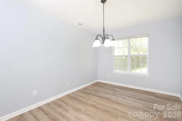 a view of a room with a window and wooden floor