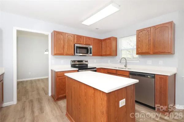 a kitchen with stainless steel appliances a sink a stove a microwave a sink a refrigerator and cabinets