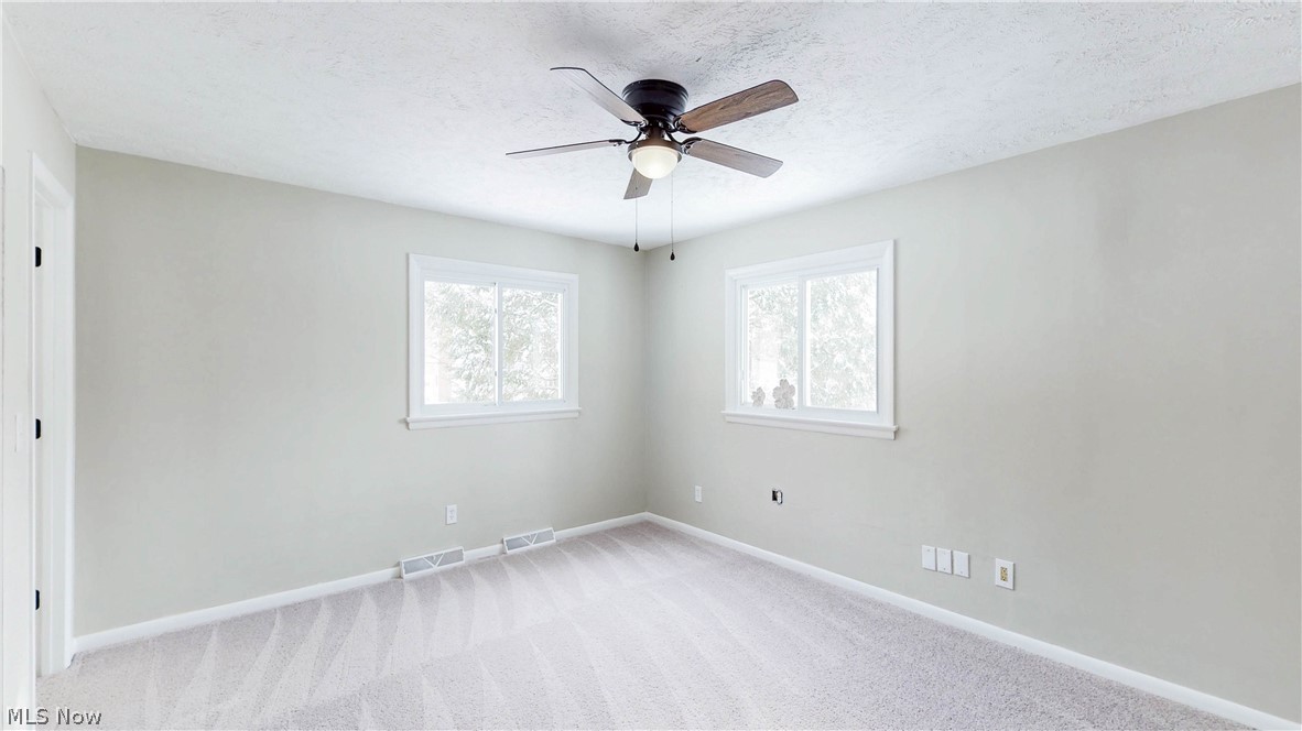 3312 Bancroft Road Akron, OH 44333 - Photo 31 of 50 Spare room featuring light carpet, healthy amount of natural light, a ceiling fan, and a textured ceiling
