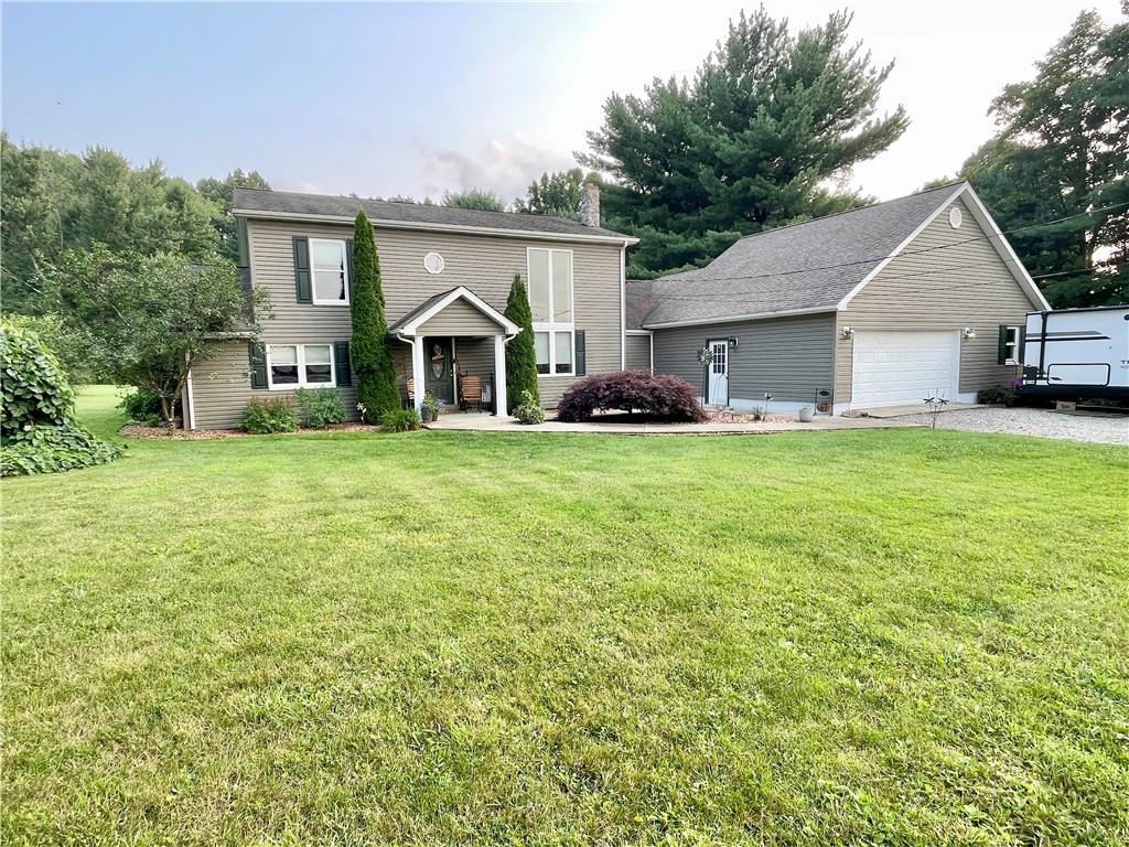 a view of a house with a big yard and large trees