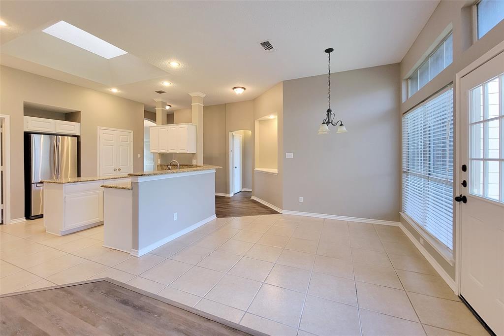 1604 Knoll Ridge Circle Corinth, TX 76210 - Photo 23 of 37 Open-concept living space featuring a breakfast bar with granite countertop, recessed lighting, and a skylight