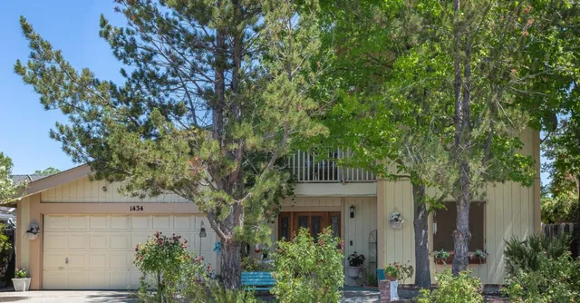 a front view of a house with a tree