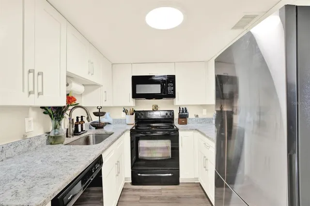 a kitchen with a refrigerator and a stove top oven